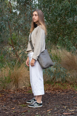 Model wears Ripple and Co Leather Jude Petite Cross Shoulder Bag Elephant Grey